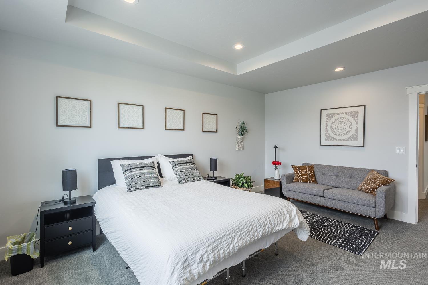 Carpeted bedroom featuring recessed lighting and a raised ceiling