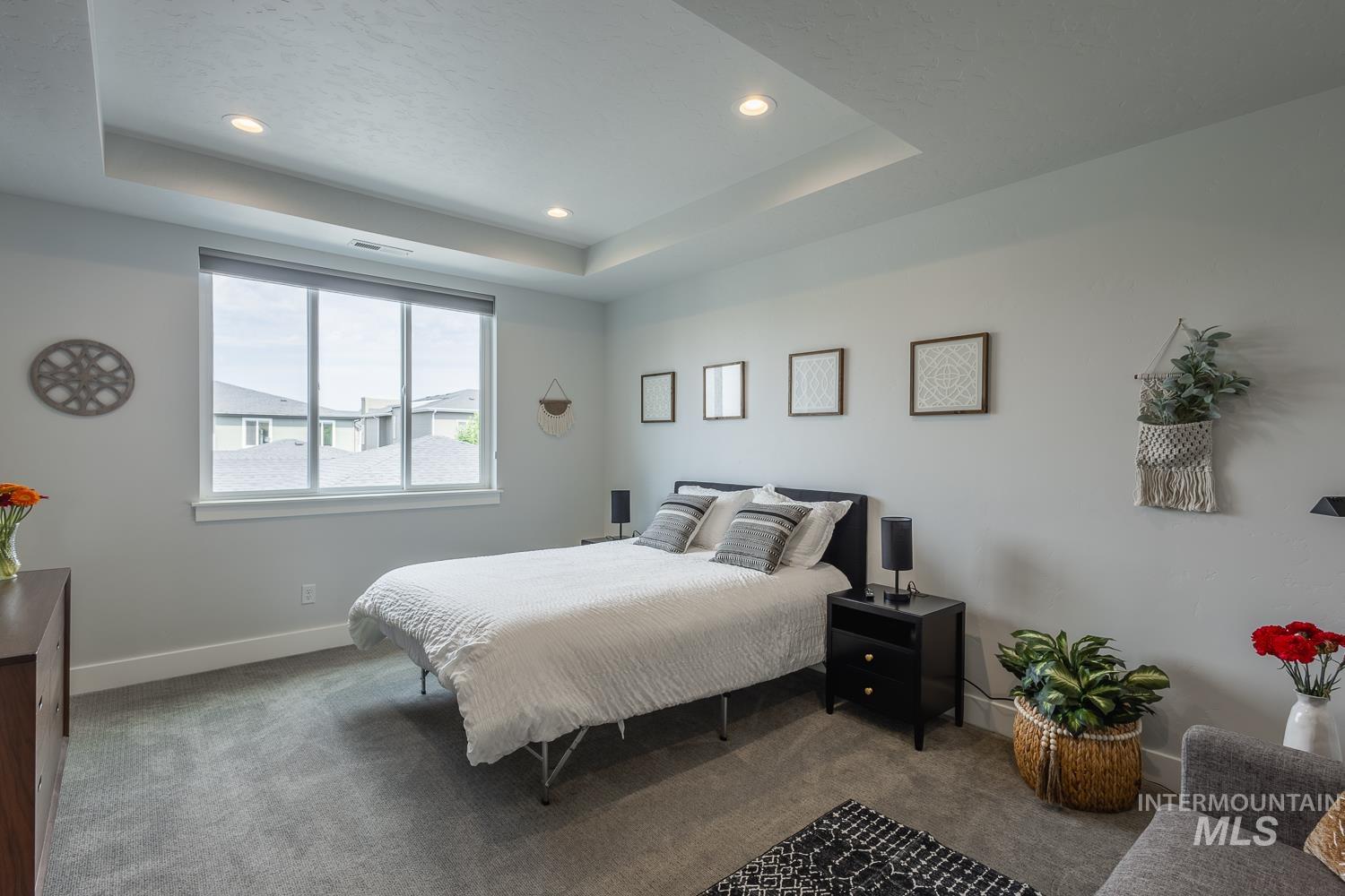 Bedroom with a tray ceiling, carpet, and recessed lighting