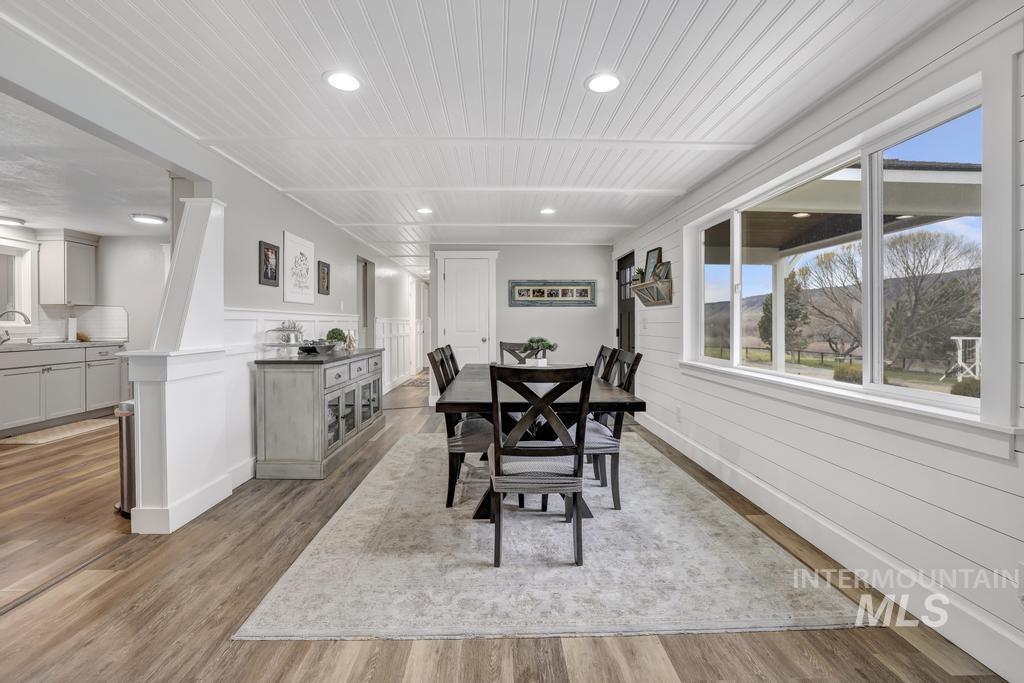 Dining space with light wood-style flooring, recessed lighting, and wainscoting