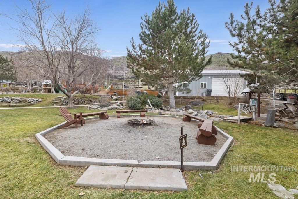 View of property's community featuring a mountain view, a yard, and a patio