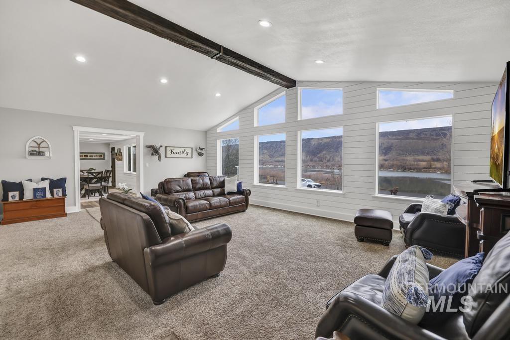 Living area with carpet, recessed lighting, and wooden walls