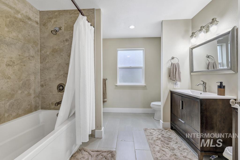 Full bathroom with shower / bath combo with shower curtain, vanity, and recessed lighting