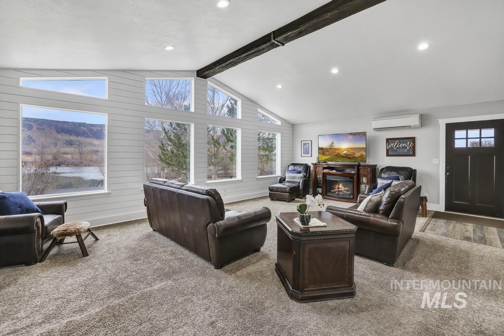Living room with carpet flooring, an AC wall unit, and recessed lighting