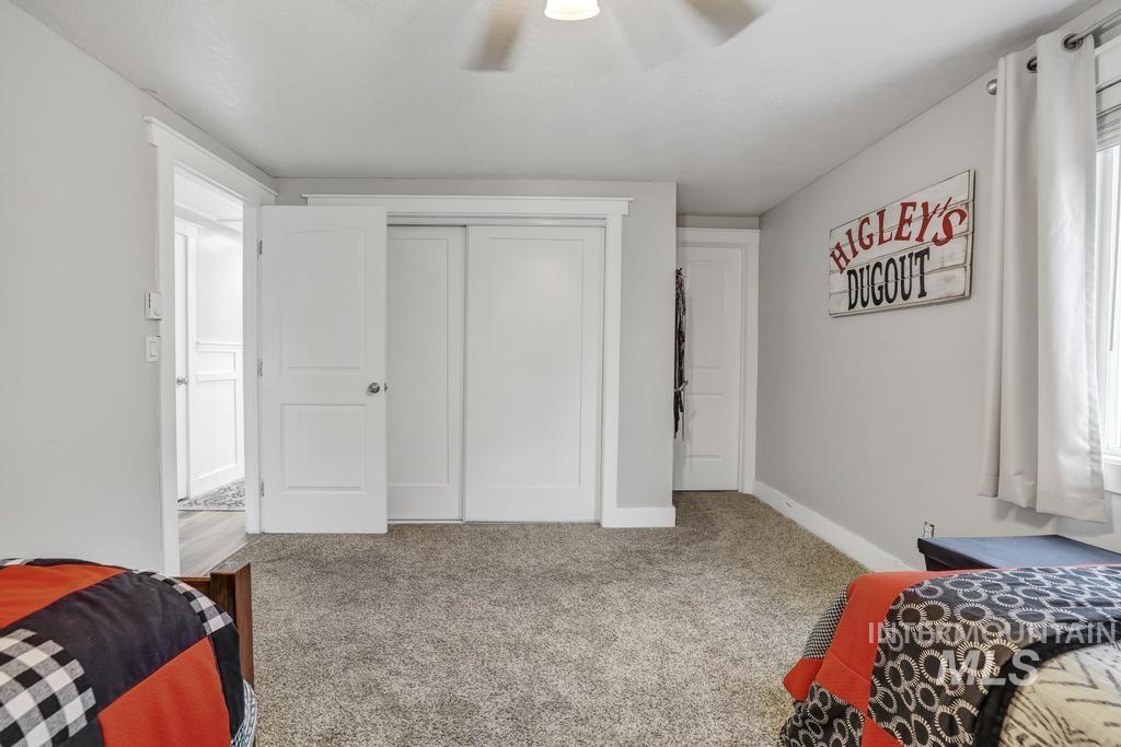 Bedroom featuring carpet, a closet, a ceiling fan, and multiple windows