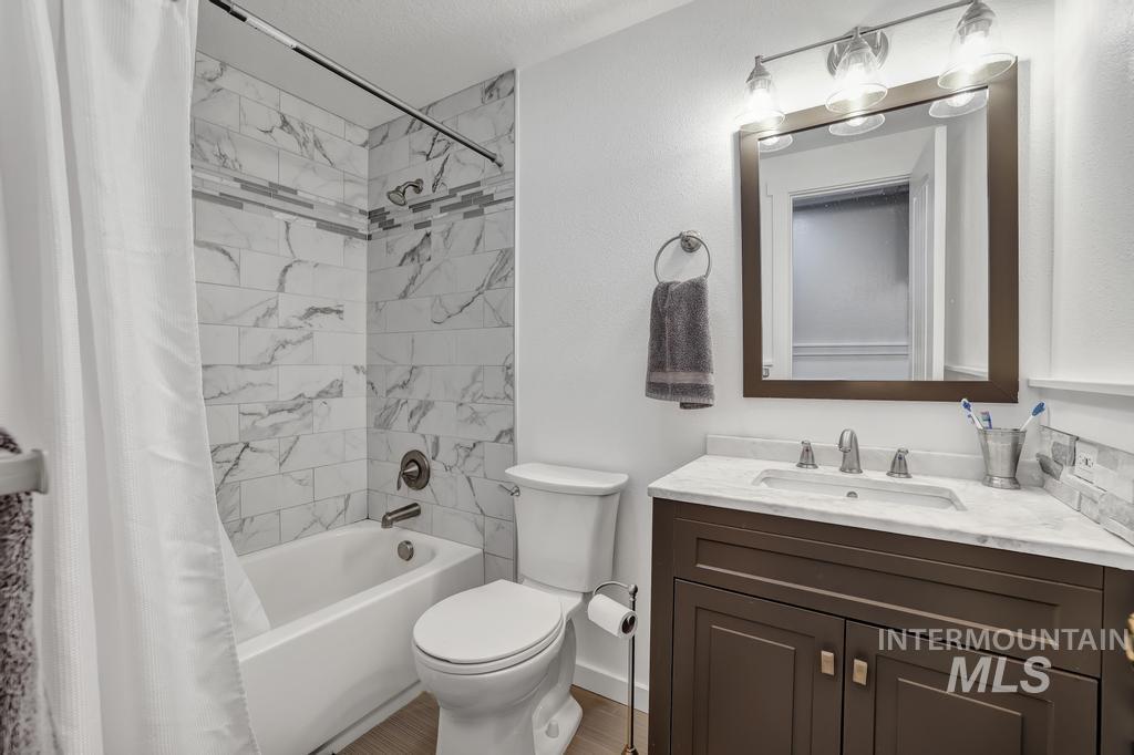 Full bathroom with shower / bath combination with curtain and vanity