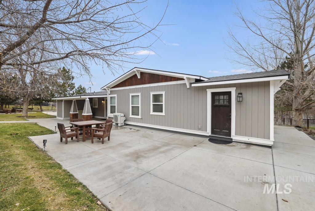 Back of property with a patio, outdoor dining space, a shingled roof, and a lawn