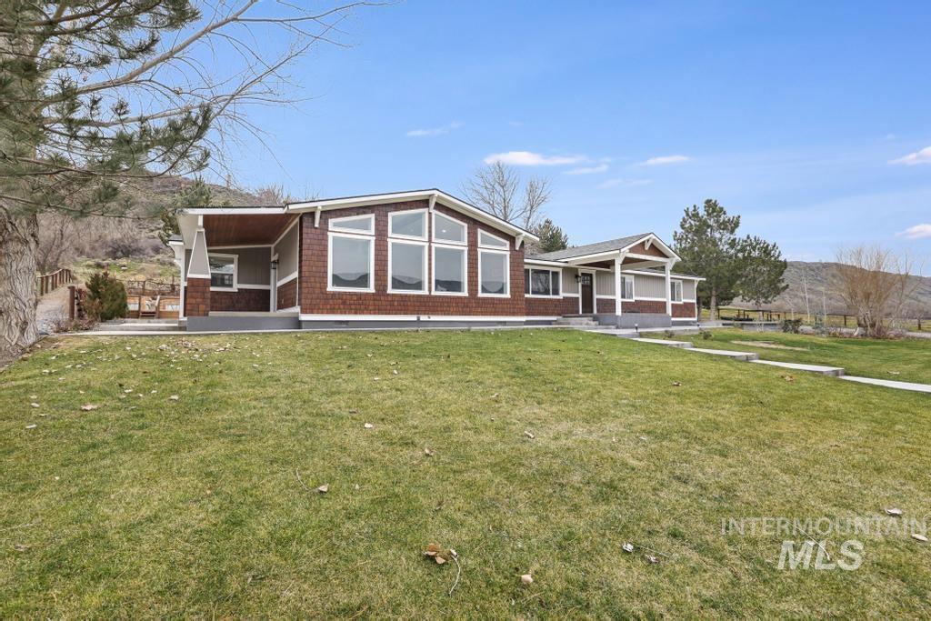 Rear view of house with a lawn and covered porch
