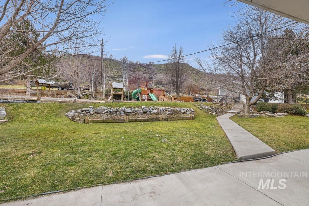 View of community featuring a playground, a lawn, and a mountain view