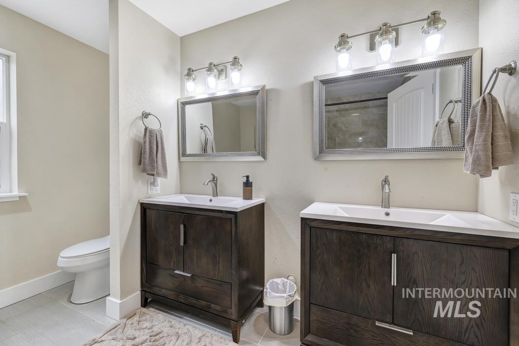 Bathroom featuring two vanities, a shower, and a textured wall