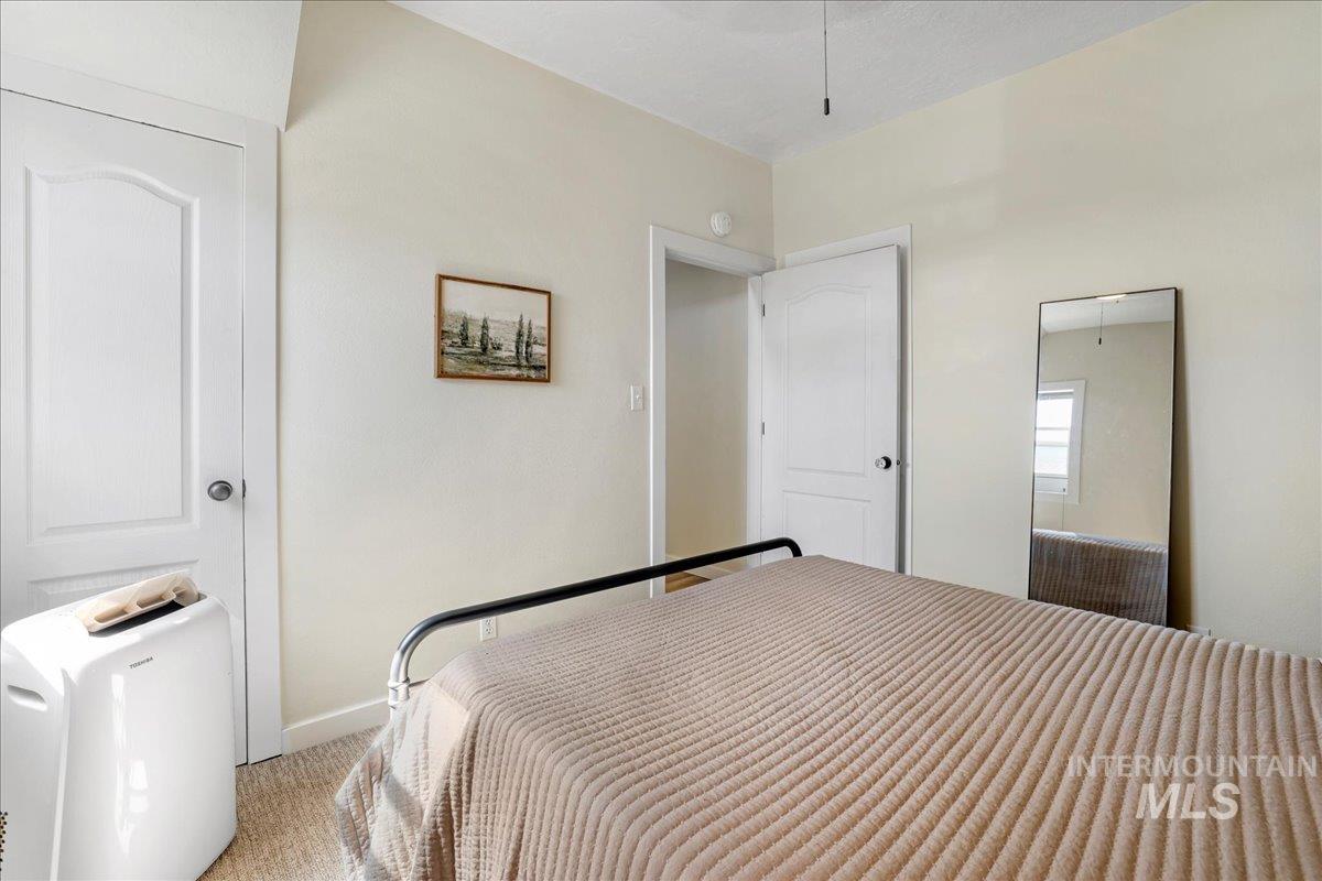 Carpeted bedroom featuring baseboards and attic access