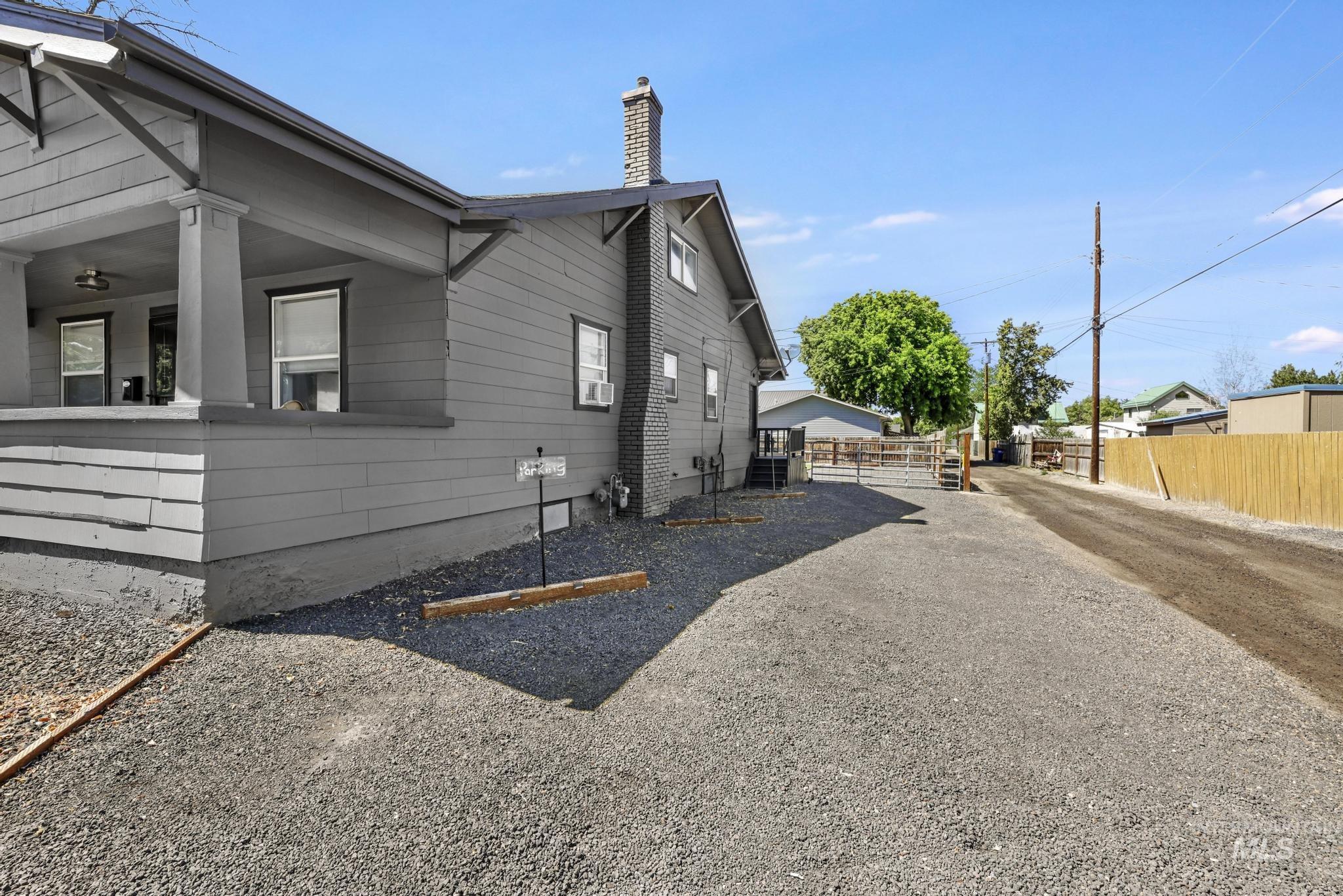 View of side of home with a chimney and cooling unit