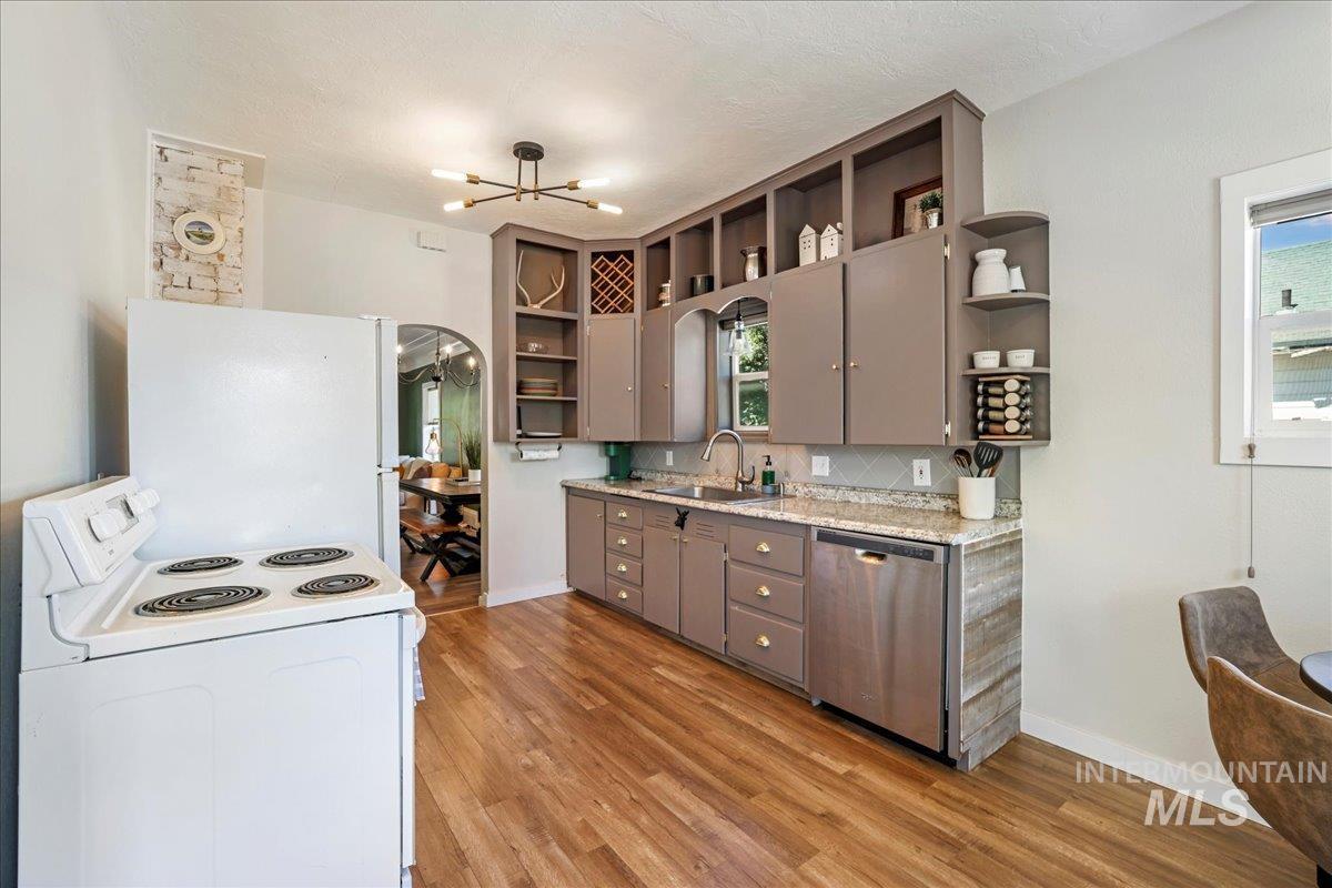 Kitchen with white appliances, open shelves, gray cabinetry, a chandelier, and light wood-style flooring