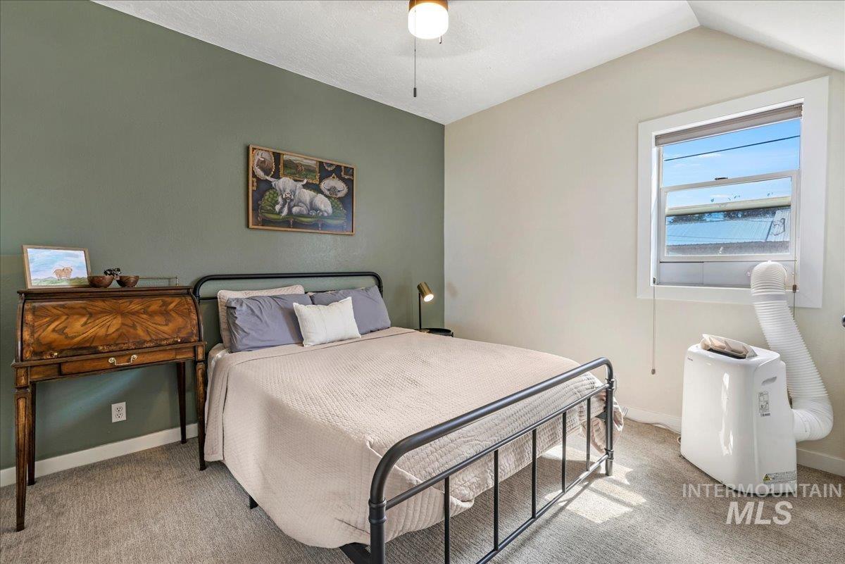 Bedroom featuring carpet flooring, lofted ceiling, and a ceiling fan