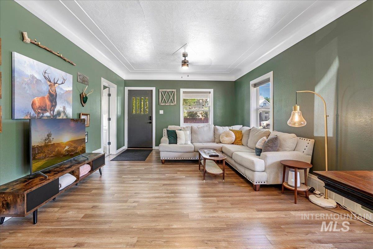 Living room with light wood-style floors, a textured ceiling, and a ceiling fan