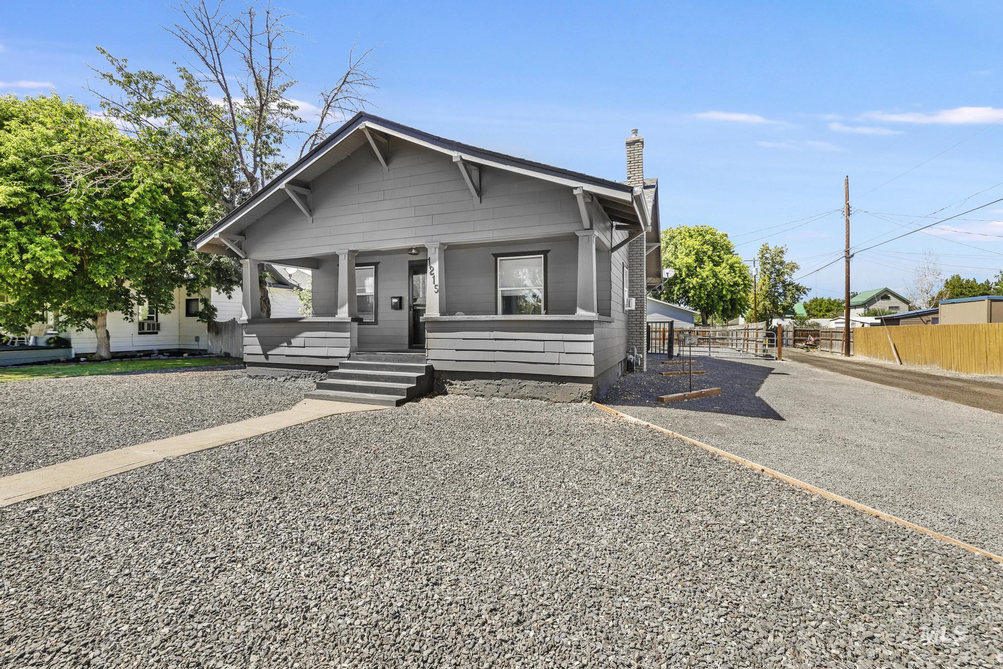 Bungalow-style home featuring a chimney and a porch