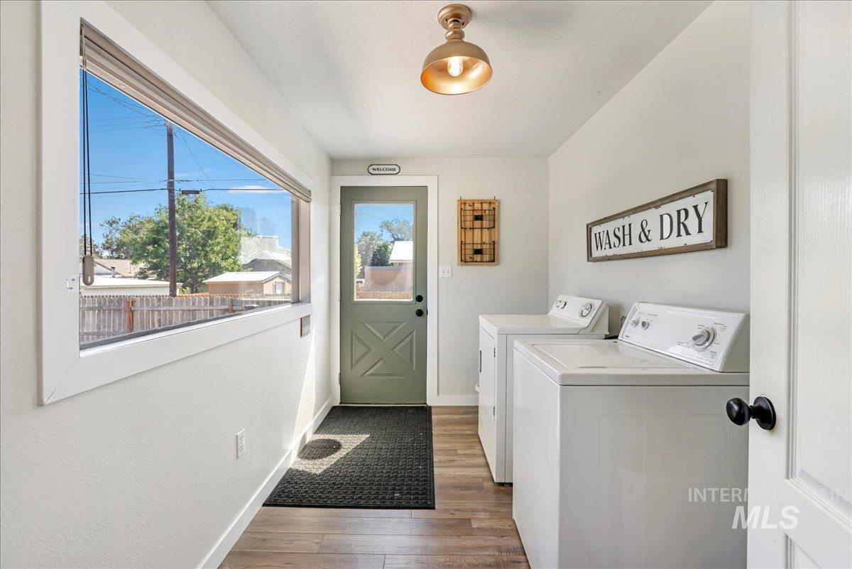 Laundry room with washing machine and clothes dryer and wood finished floors