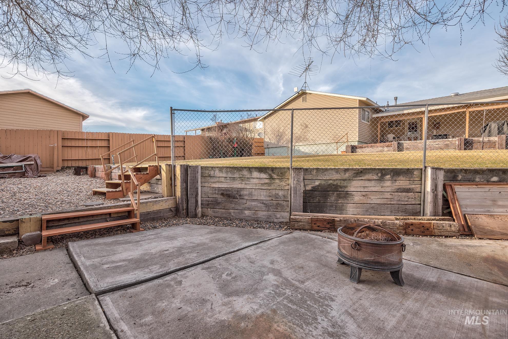 Fenced backyard featuring a patio area and an outdoor fire pit