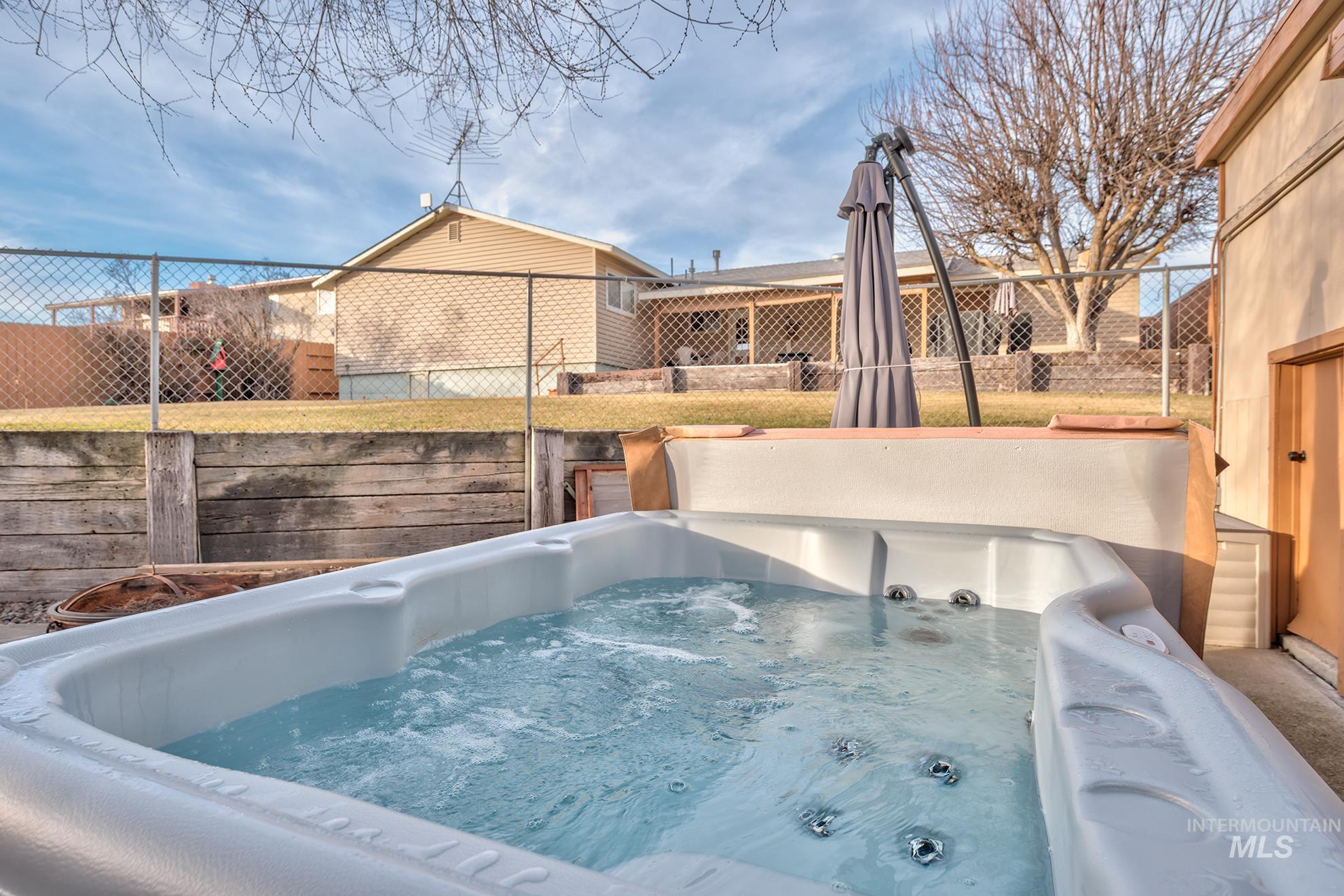 View of pool featuring a fenced backyard and a hot tub