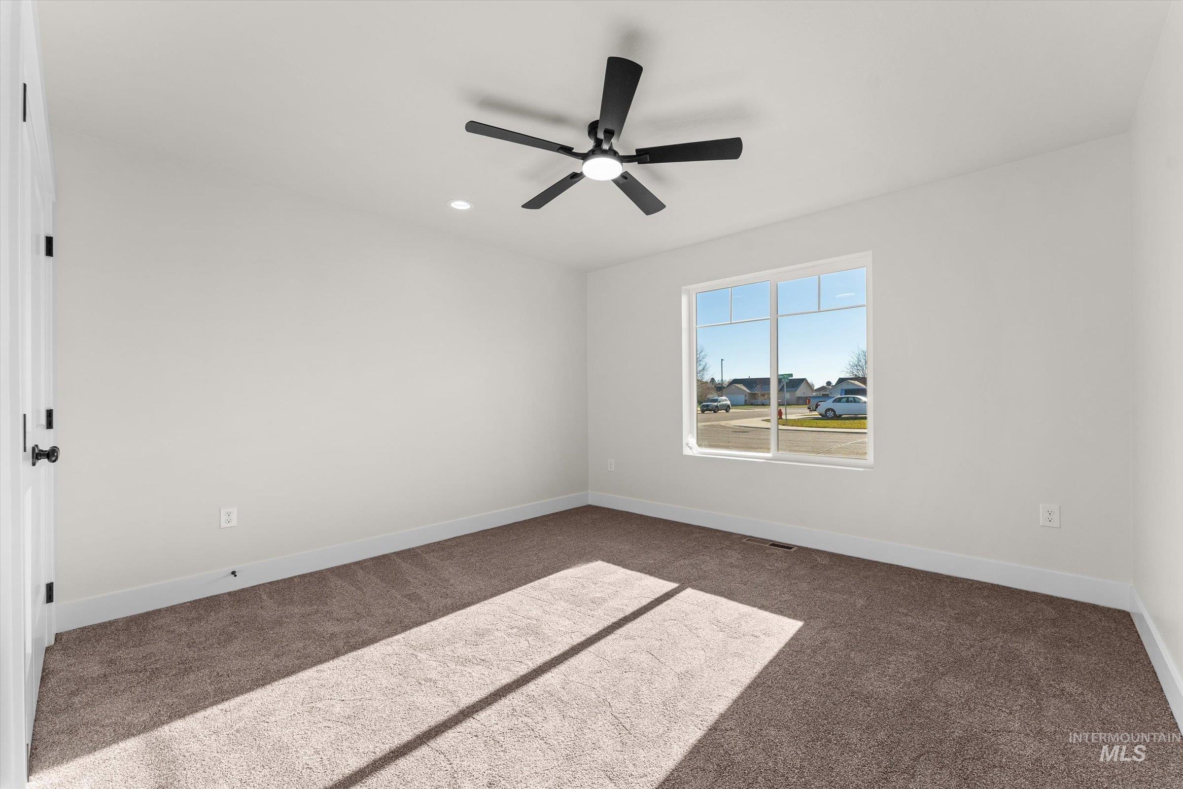 Spare room with dark carpet, recessed lighting, and a ceiling fan