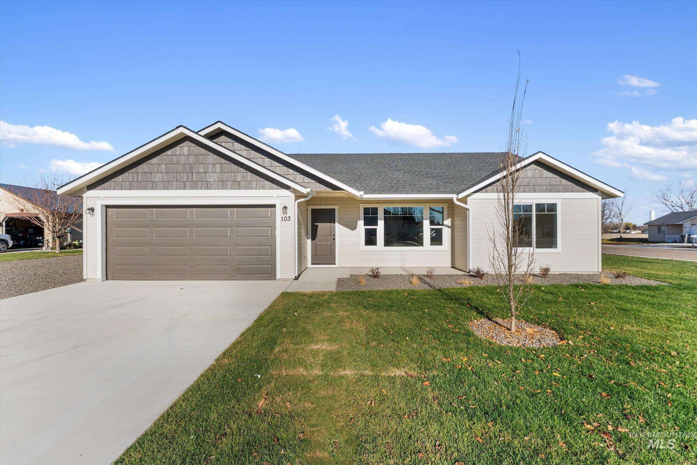 View of front of house featuring a front yard, concrete driveway, a shingled roof, and a garage