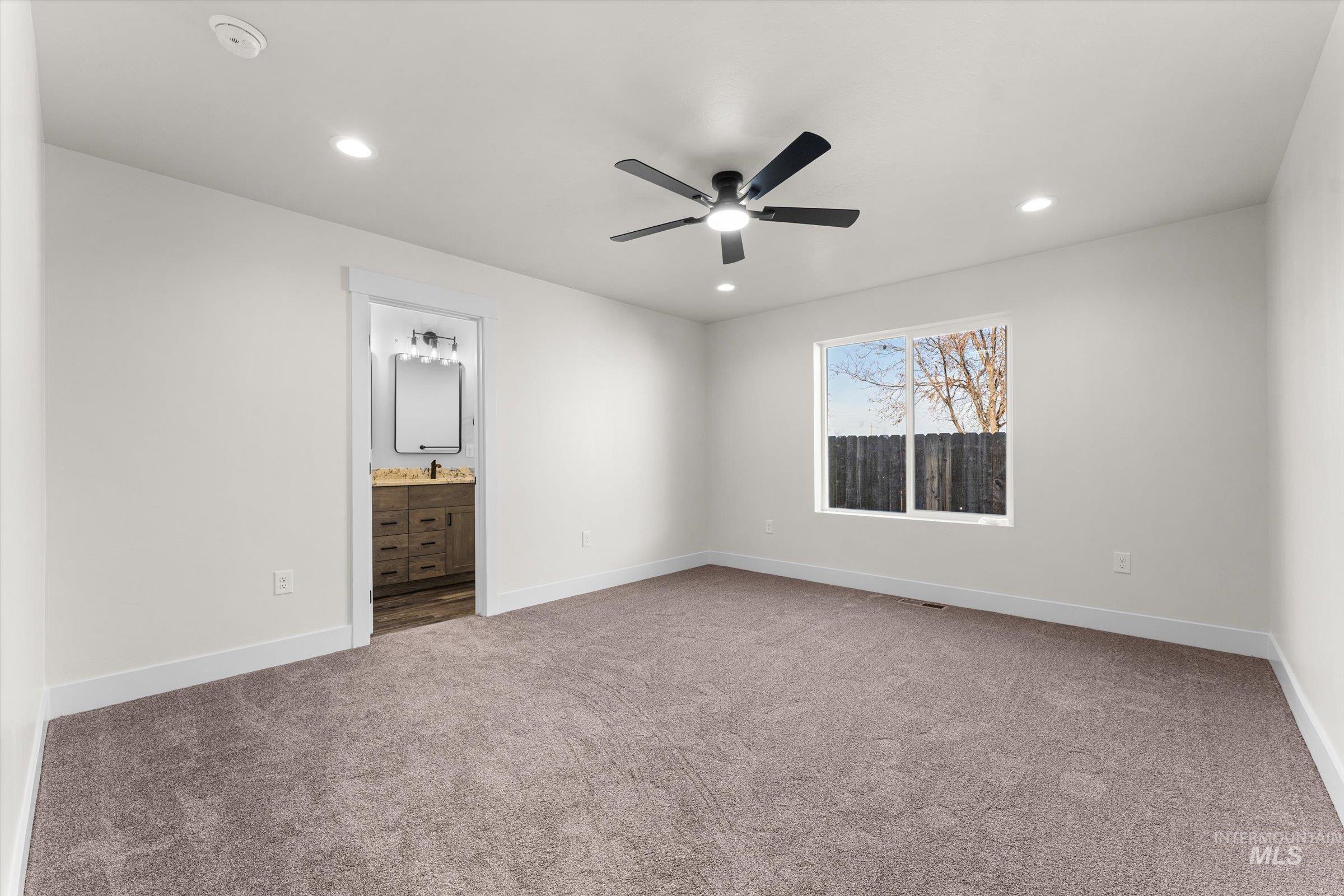 Unfurnished bedroom featuring a ceiling fan, light carpet, recessed lighting, and ensuite bathroom