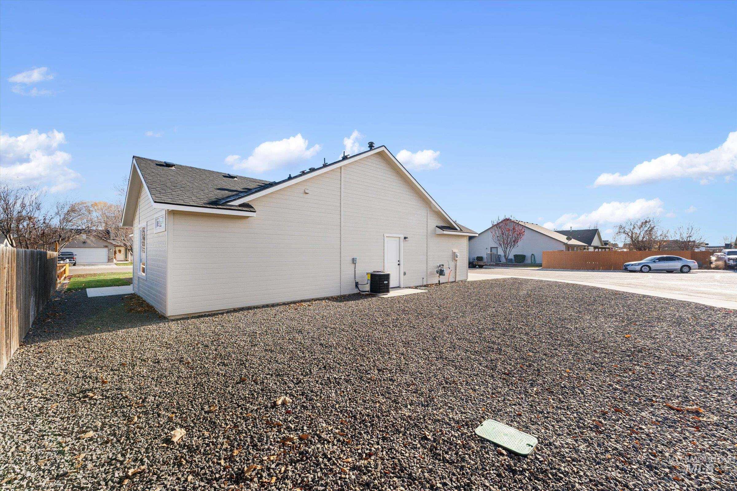 View of side of home with a shingled roof and a cooling unit