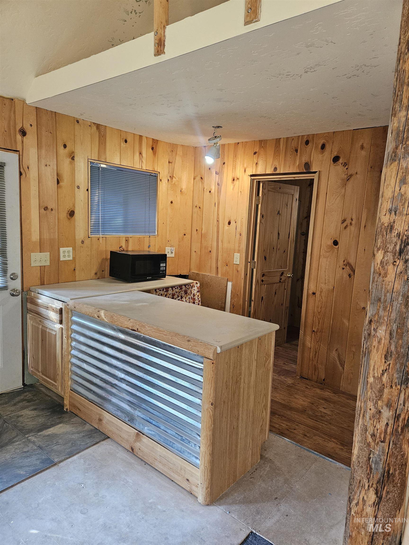 Kitchen with wood walls and black microwave