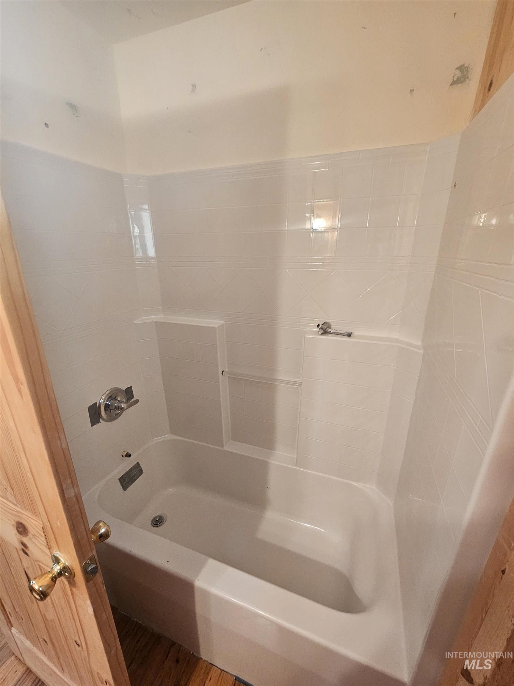 Full bathroom with shower / tub combination and wood finished floors