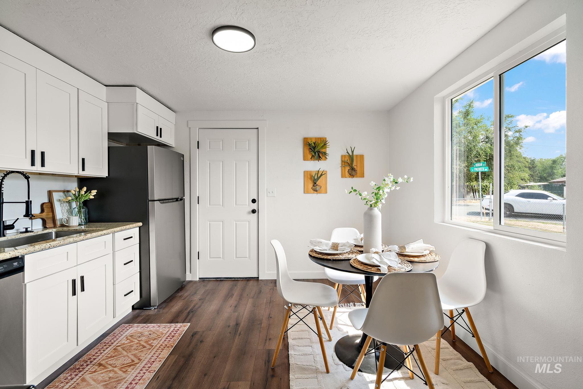Dining space with a textured ceiling and dark wood-style floors