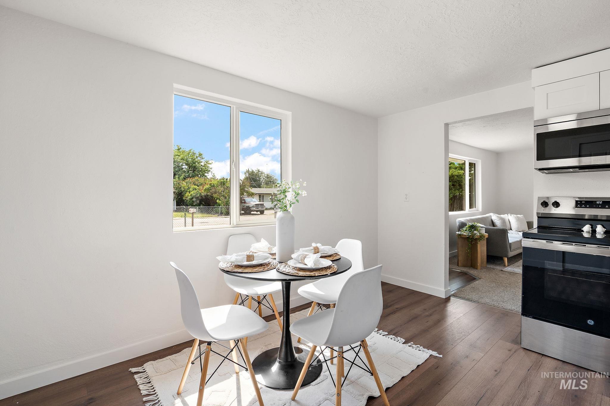 Dining room with dark wood-type flooring and a textured ceiling
