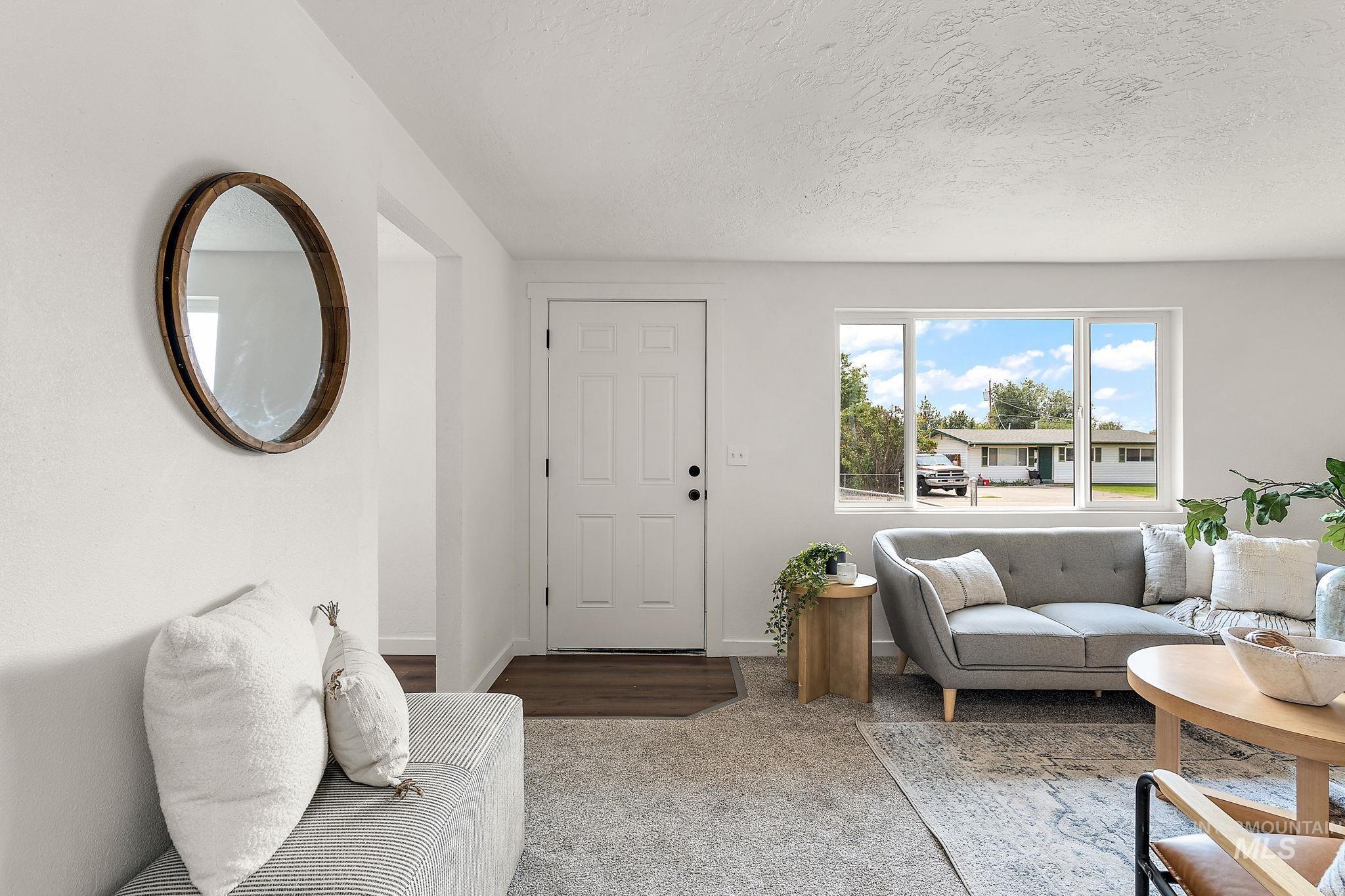 Living room featuring carpet and a textured ceiling