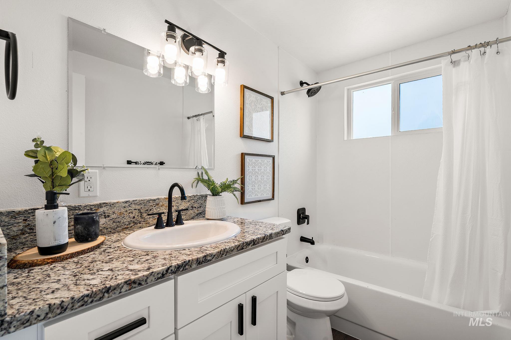 Full bath featuring shower / tub combo and vanity