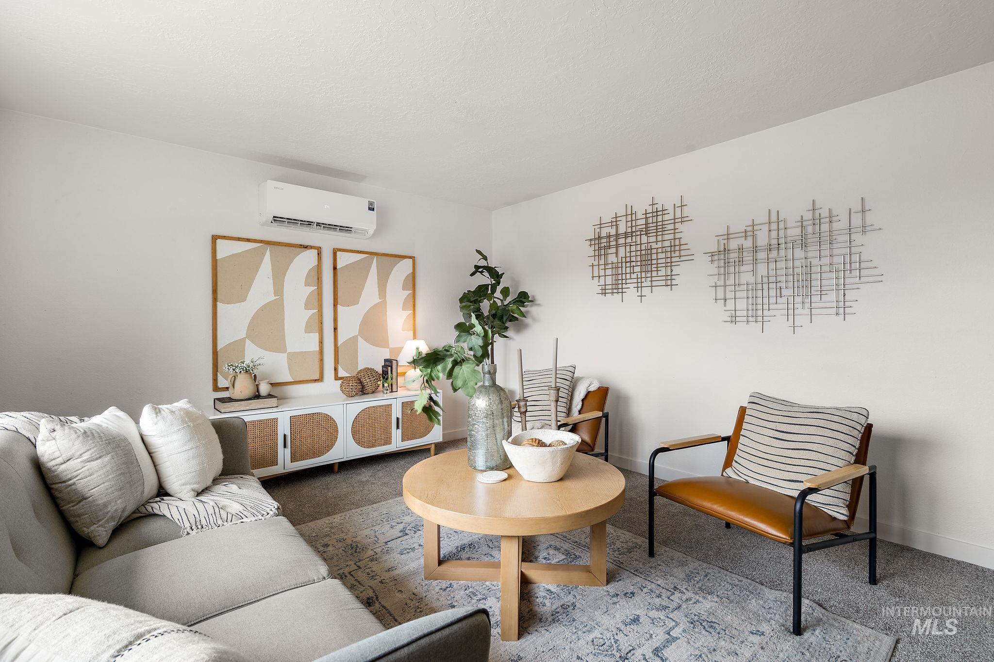 Living area with carpet floors and a wall mounted AC