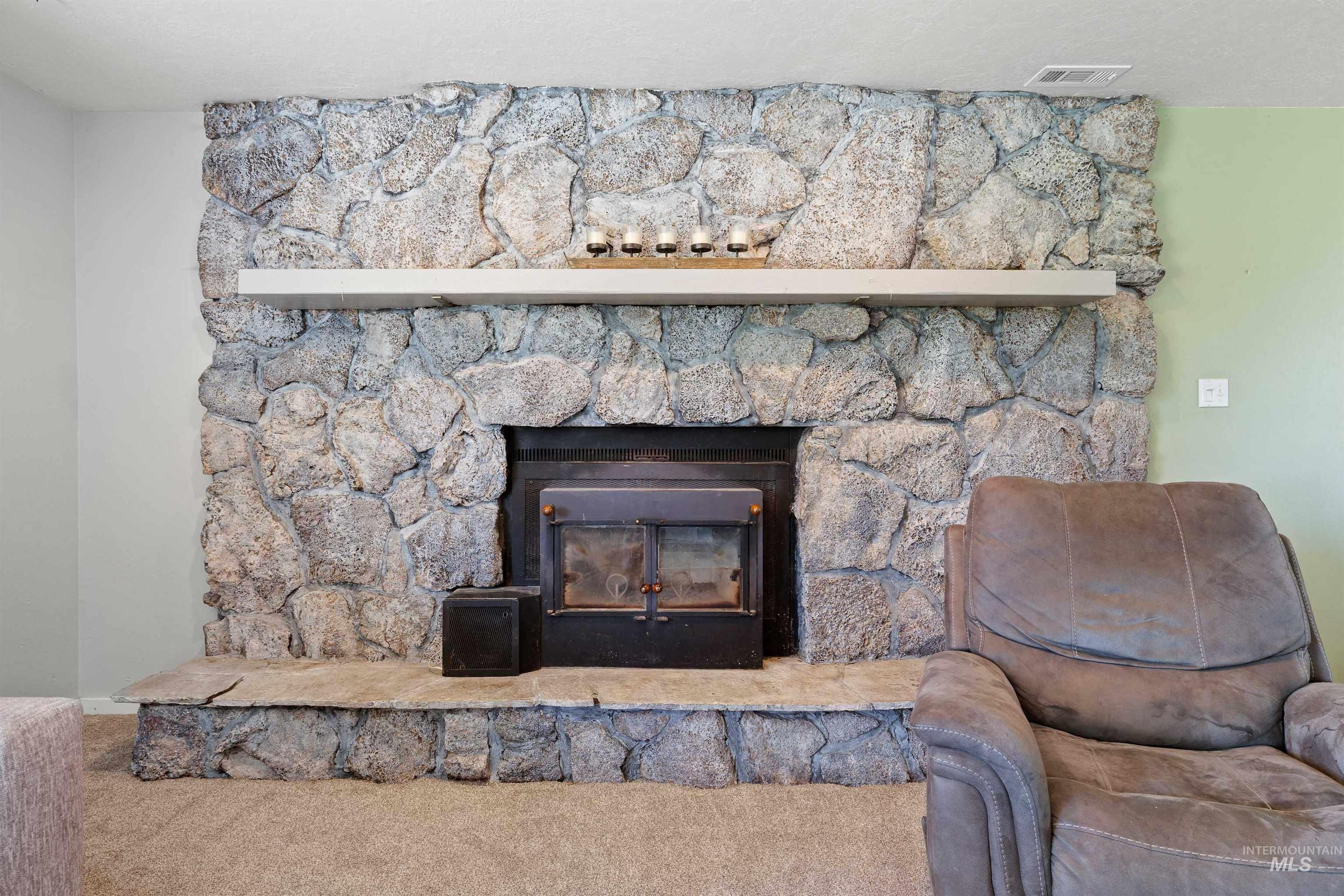Detailed view of carpet floors and a stone fireplace