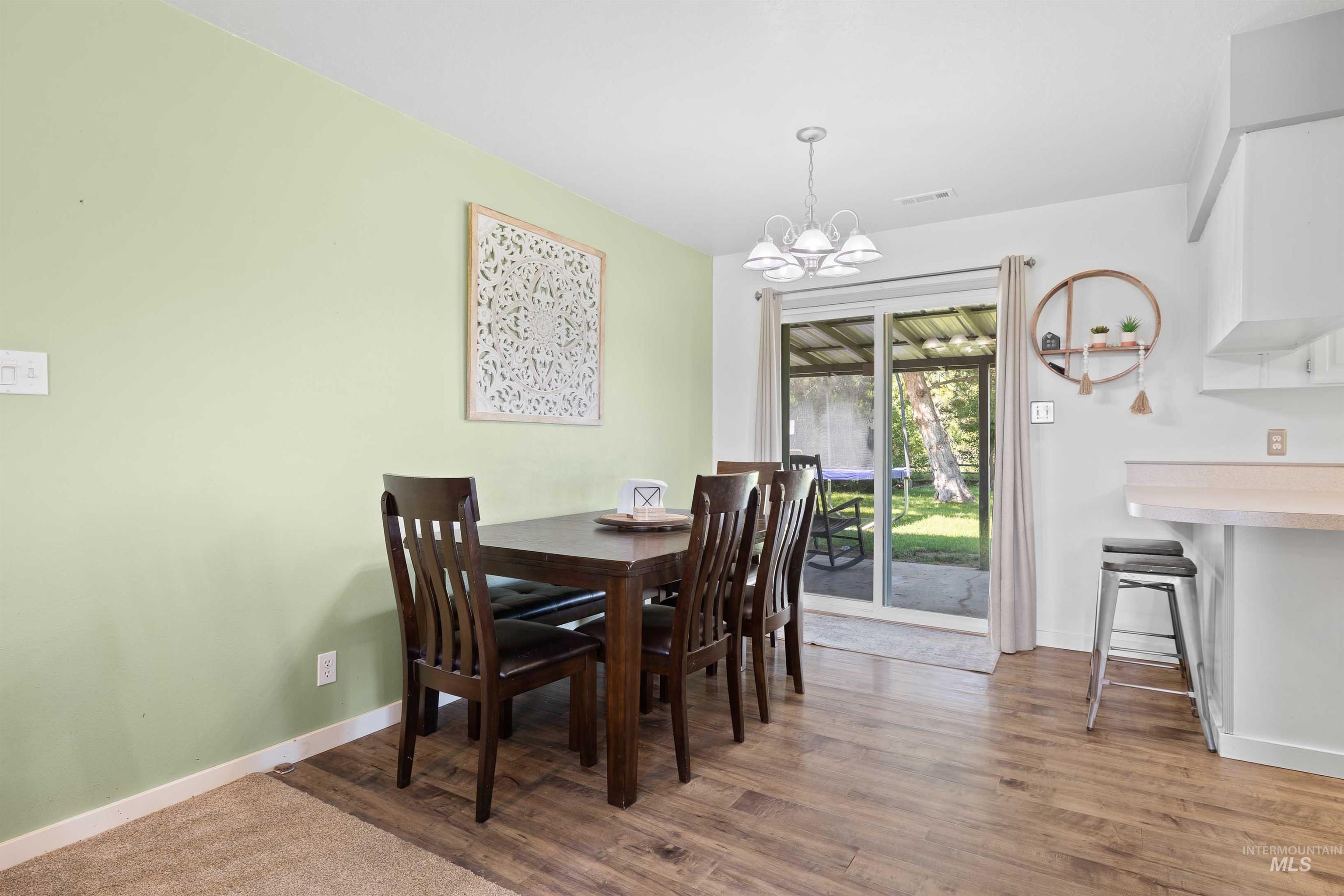 Dining space with a chandelier and wood finished floors