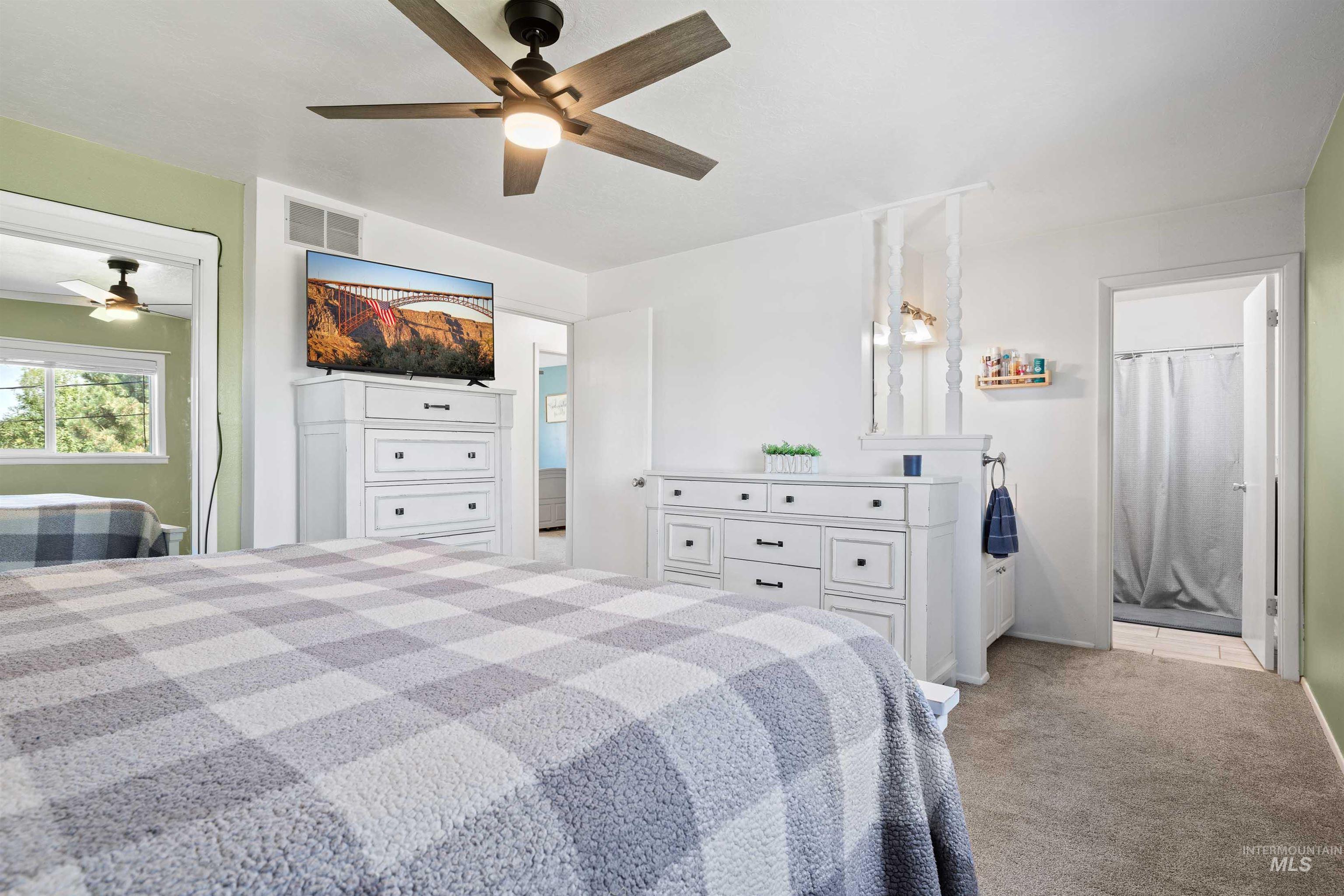 Bedroom with light colored carpet and ceiling fan