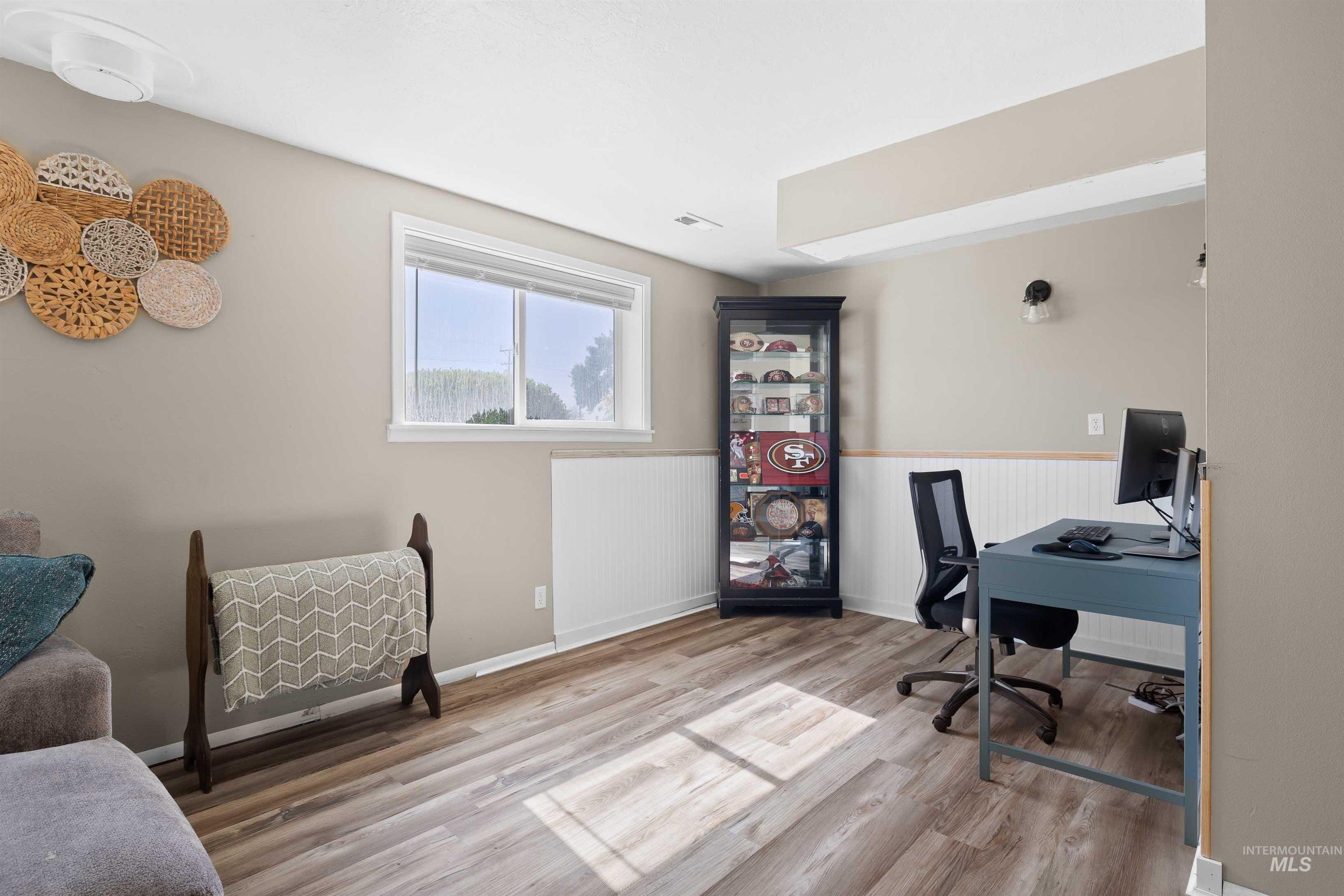 Office space with wainscoting and wood finished floors