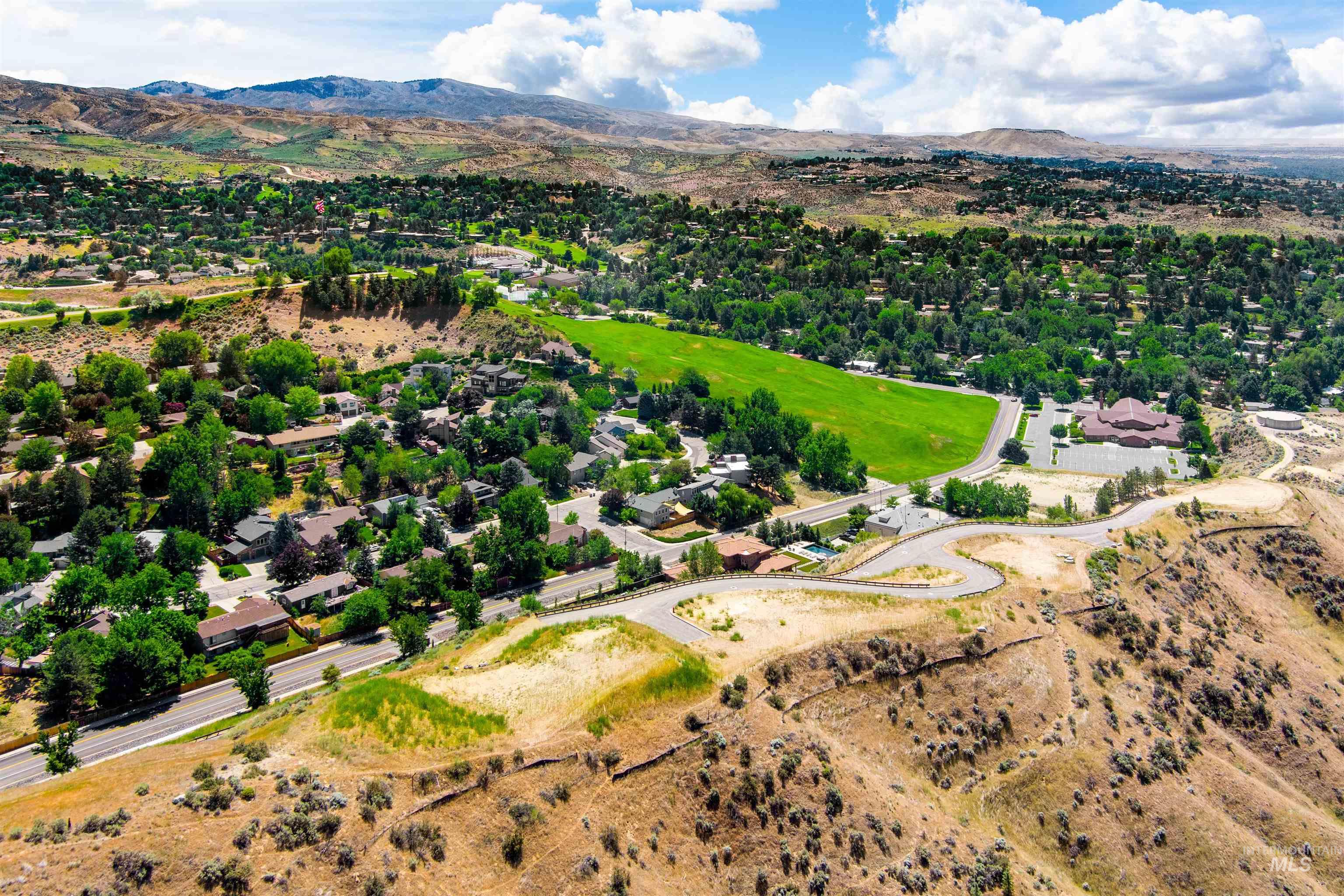Aerial view of property and surrounding area featuring a mountain backdrop