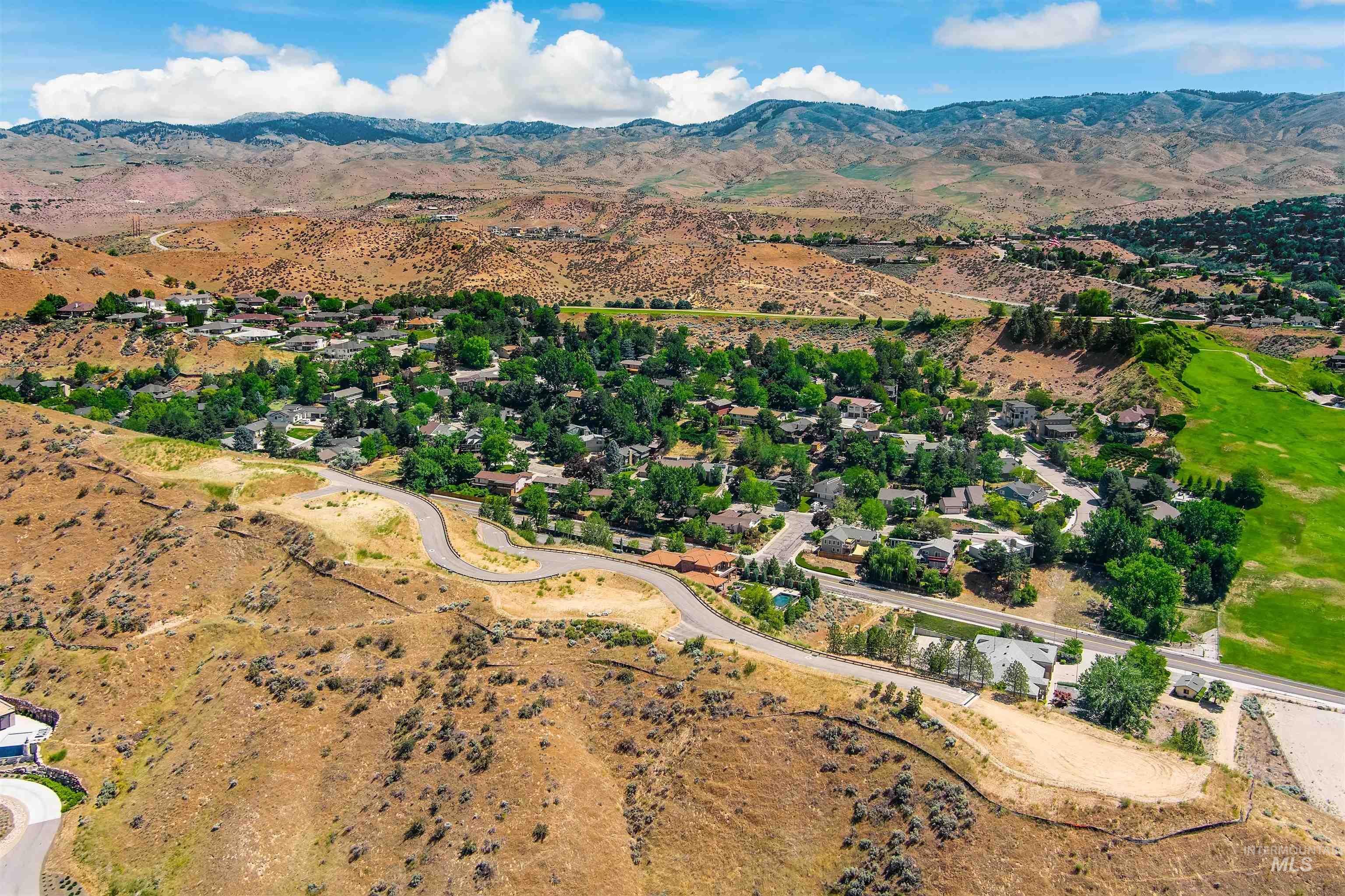 Aerial view of property's location featuring a mountainous background