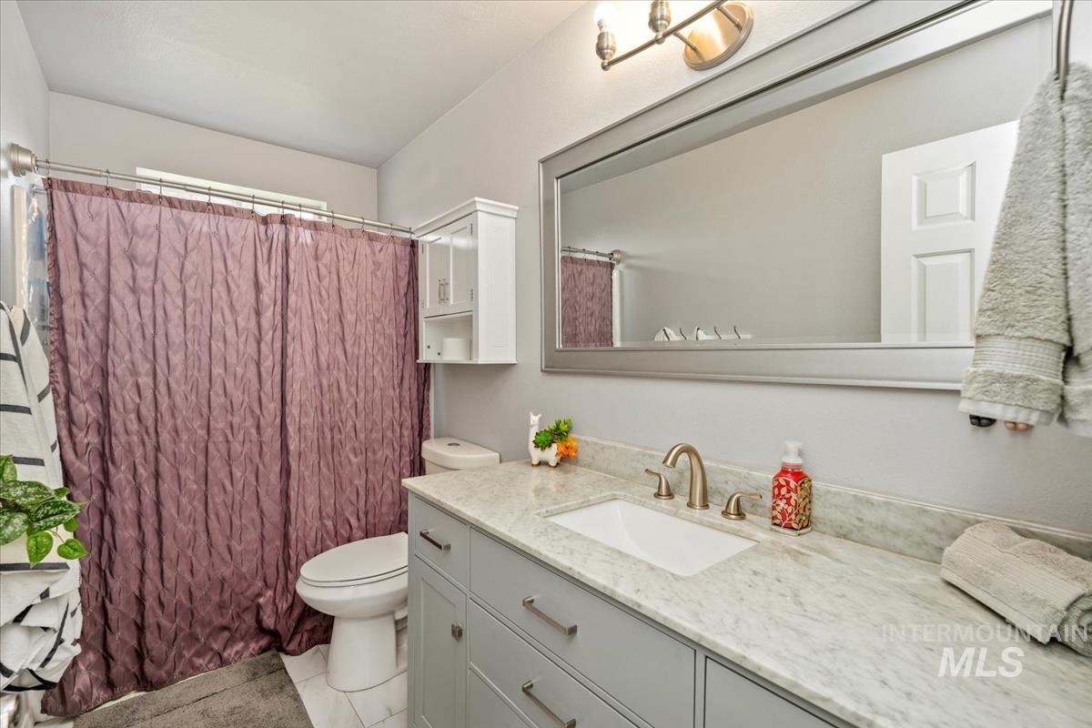 Full bathroom featuring vanity, tile patterned flooring, and a shower with curtain