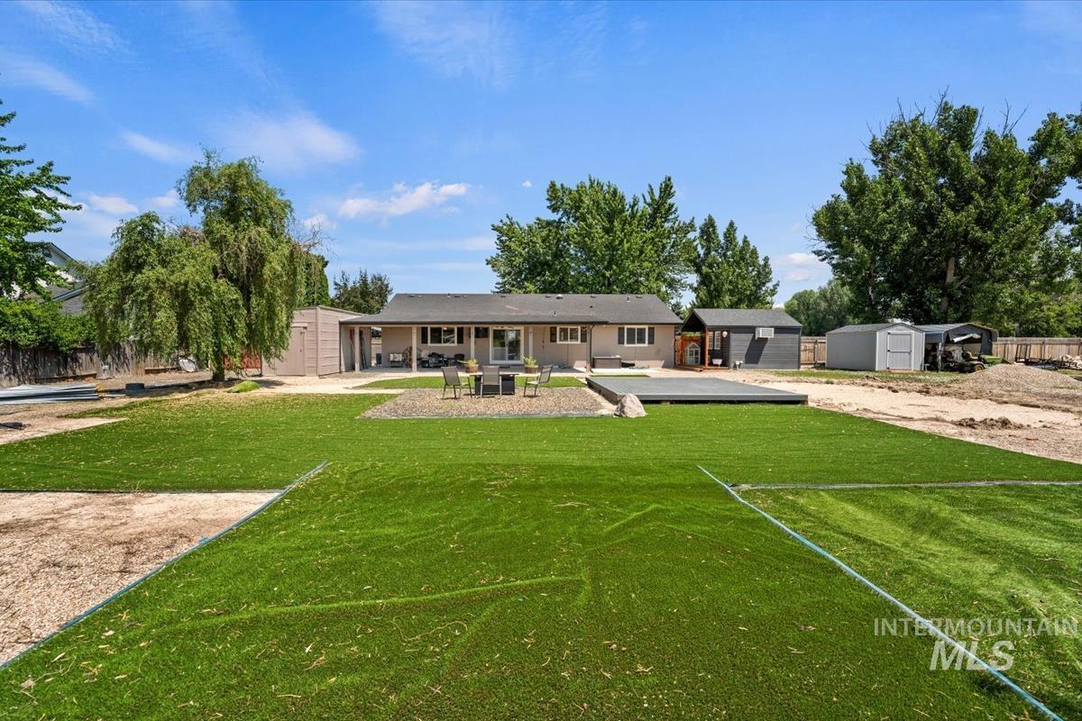Rear view of house featuring a storage unit and a patio area
