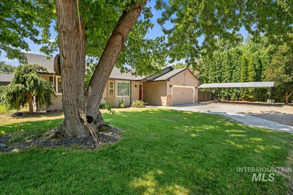View of front of home featuring driveway, an attached garage, and a front lawn