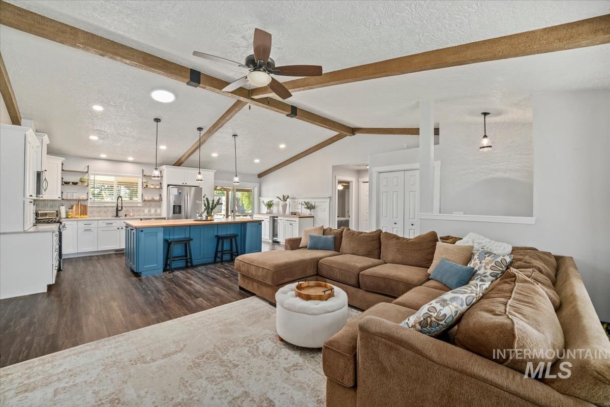 Living room with a textured ceiling, dark wood finished floors, a ceiling fan, and recessed lighting