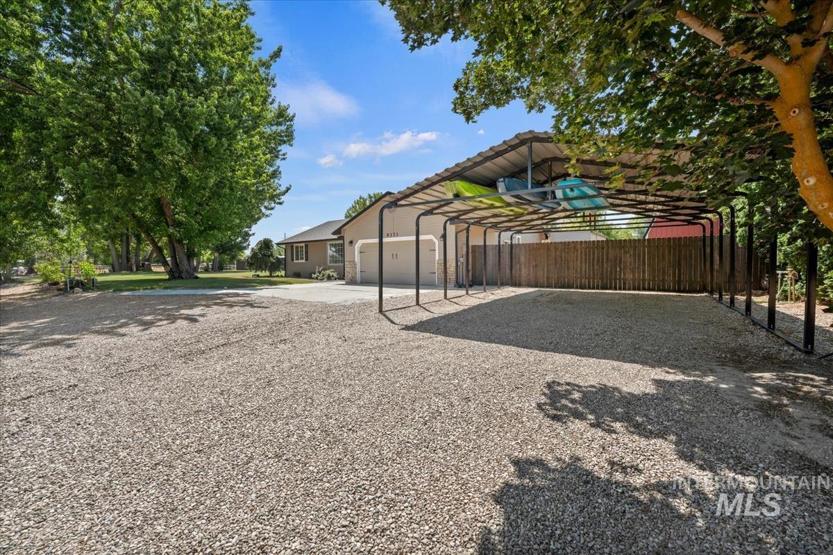 View of yard with a carport and driveway