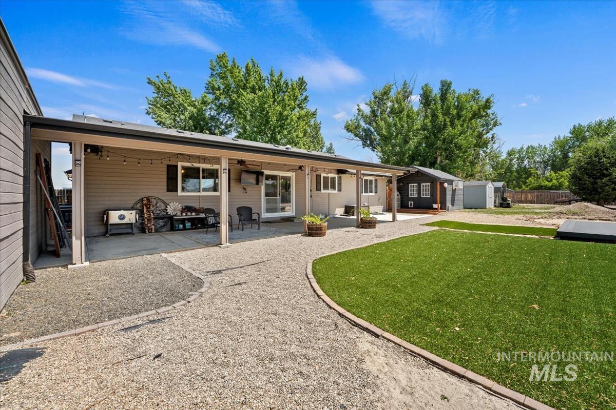 Rear view of property with a storage shed, a patio, and a ceiling fan