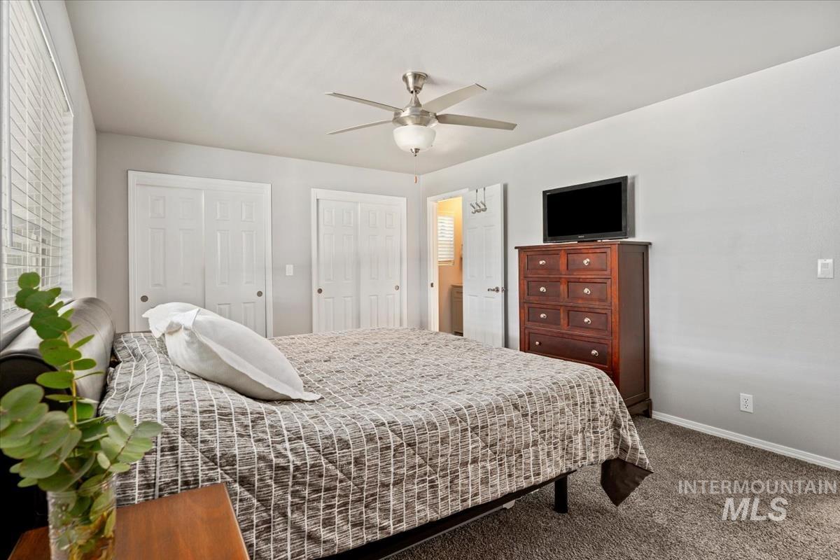 Bedroom featuring carpet flooring, multiple closets, and ceiling fan