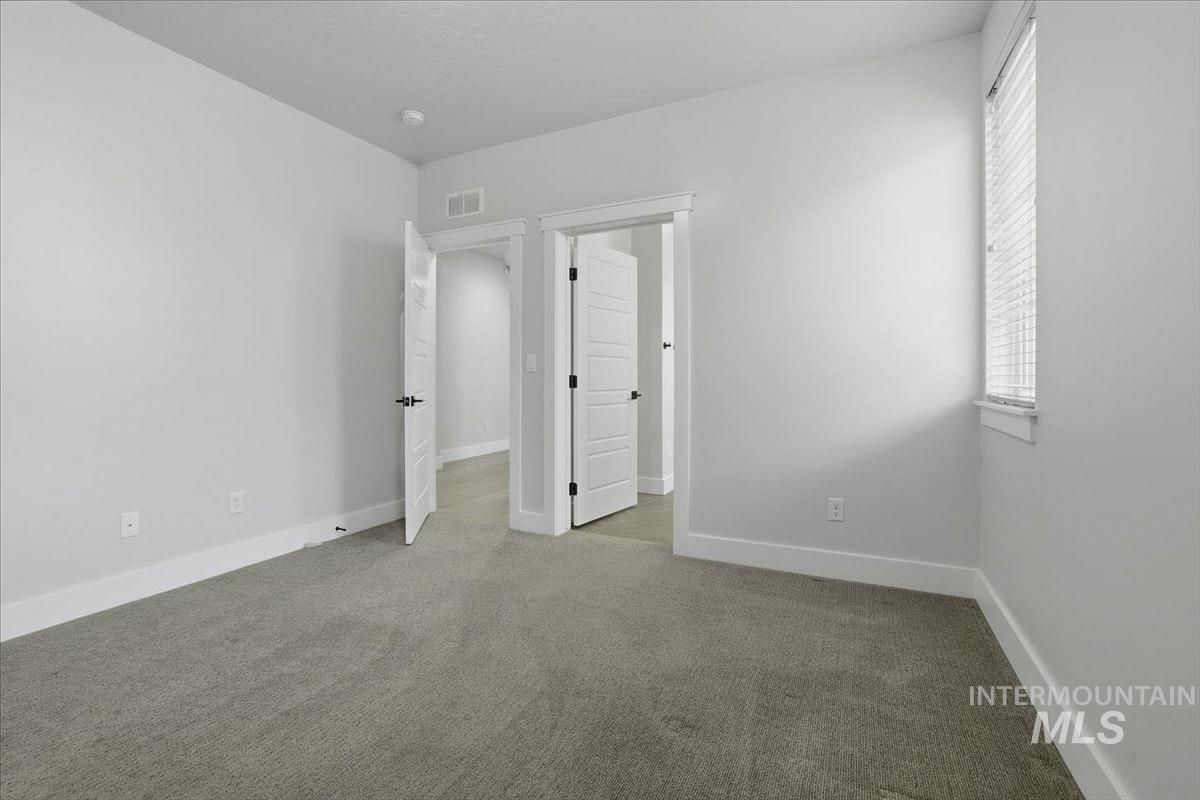 Unfurnished bedroom with baseboards and light colored carpet