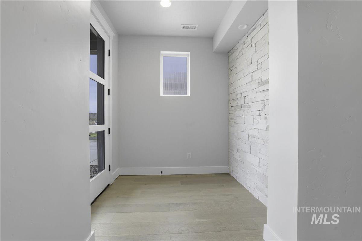 Spare room featuring light wood-type flooring and baseboards