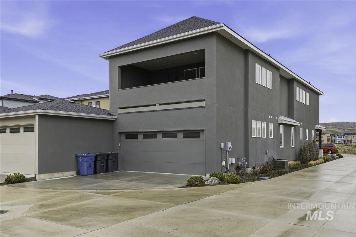 View of property exterior featuring stucco siding, a garage, and driveway