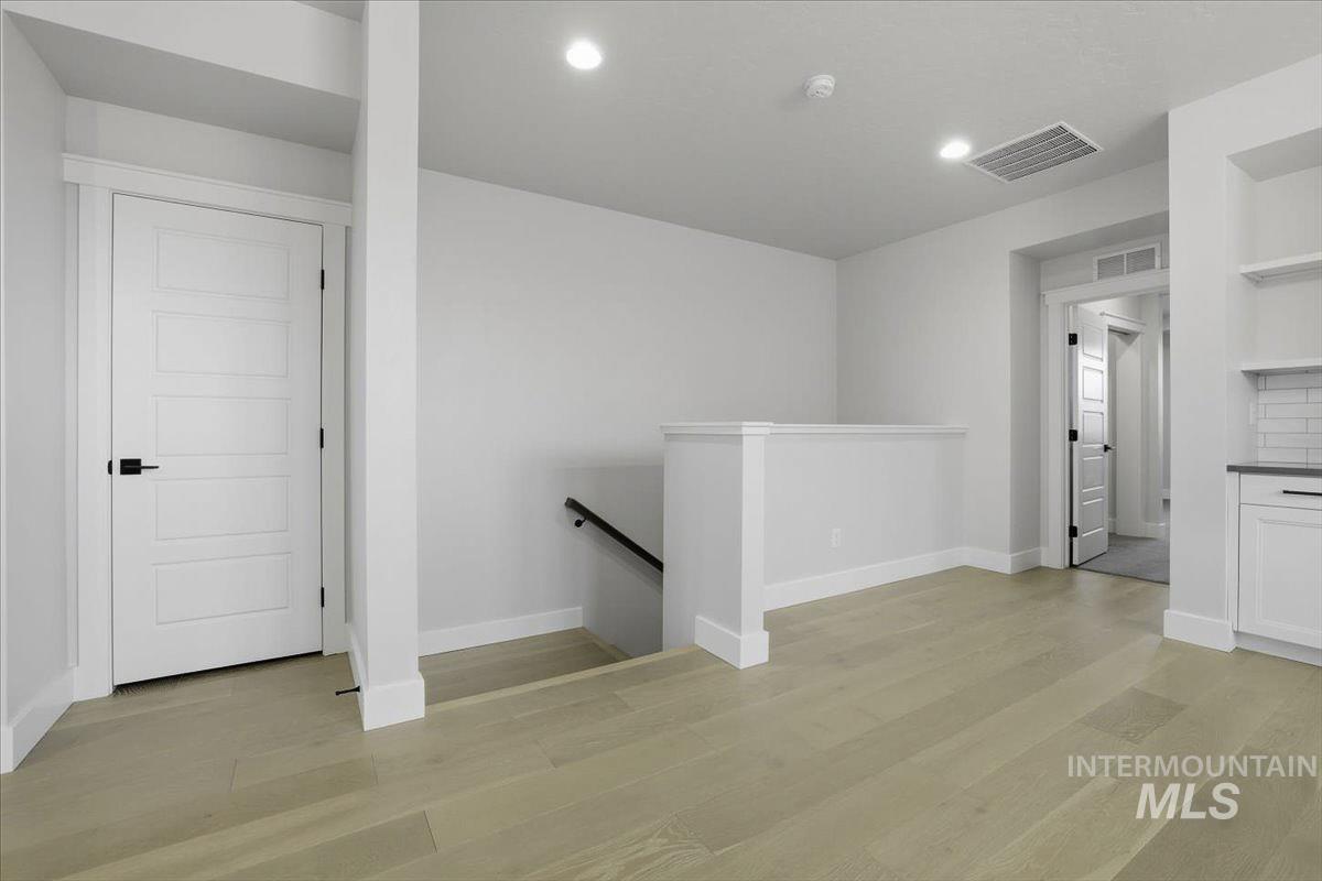 Empty room featuring light wood finished floors and recessed lighting